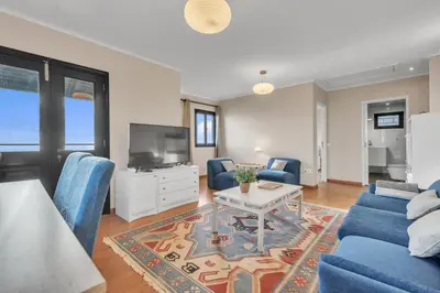 a living room with a blue couch and a tv at Chalé do Areeiro in Funchal