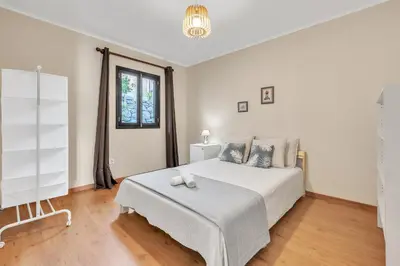 a white bedroom with a bed and a window at Chalé do Areeiro in Funchal