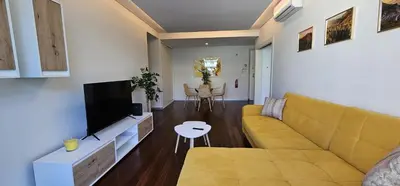 a living room with a yellow couch and a tv at Ponte de Estrelas Plaza by Rentallido in Funchal