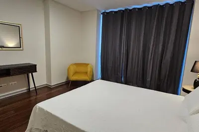 a bedroom with a bed and a desk and a window at Ponte de Estrelas Plaza by Rentallido in Funchal