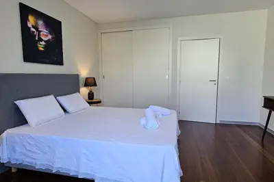 a bedroom with a large bed with white sheets at Ponte de Estrelas Plaza by Rentallido in Funchal