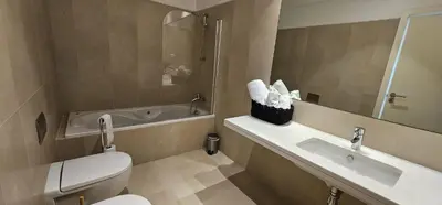 a bathroom with a toilet and a sink and a tub at Ponte de Estrelas Plaza by Rentallido in Funchal