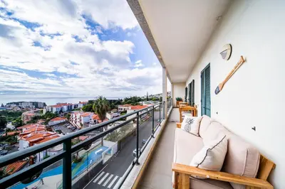 a balcony with a couch and a view of a city at Island Feeling in Funchal
