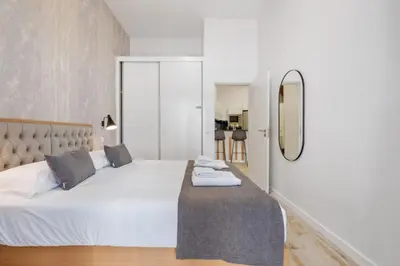 a bedroom with a white bed and a mirror at Tanoeiros Residence by An Island Apart in Funchal