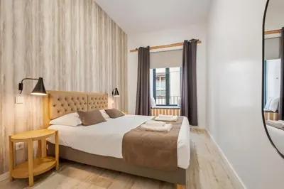 a bedroom with a large bed and a mirror at Tanoeiros Residence by An Island Apart in Funchal