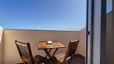 a small table and chairs on a balcony at Lucy Sweet Home by LovelyStay in Caniço
