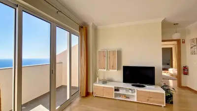 a living room with a television and large windows at Lucy Sweet Home by LovelyStay in Caniço