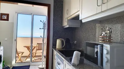 a kitchen with a view of the ocean from a balcony at Lucy Sweet Home by LovelyStay in Caniço