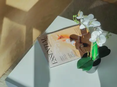 a book and a vase of flowers on a table at Barreiros ArchDesign Apartment in Funchal