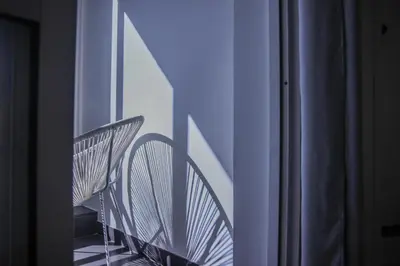 a shadow of two chairs on a wall at Barreiros ArchDesign Apartment in Funchal