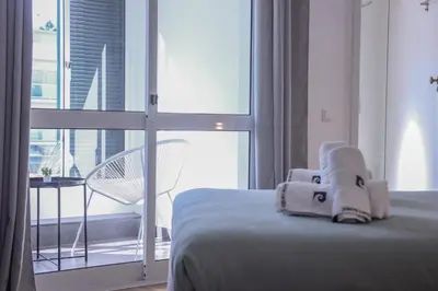 a bed with a stuffed animal sitting on top of it at Barreiros ArchDesign Apartment in Funchal