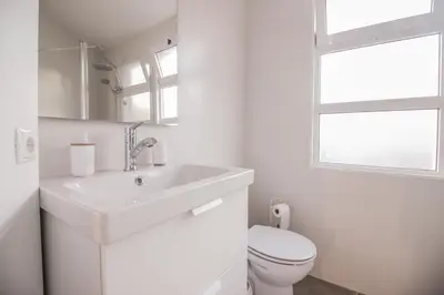 a white bathroom with a sink and a toilet at Barreiros ArchDesign Apartment in Funchal