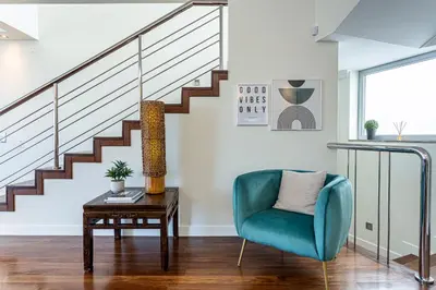 a living room with a blue chair and stairs at Moradia Vista Atlântico in Funchal