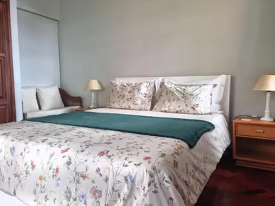 a bedroom with a large bed with flowers on it at Studio em Machico in Machico