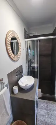 a bathroom with a sink and a shower and a mirror at Studio em Machico in Machico