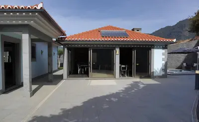 a house with a solar roof and a patio at Casa Da Achada, By OP in São Vicente