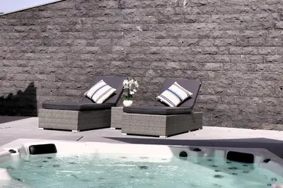 two chairs with pillows sitting next to a swimming pool at Casa Da Achada, By OP in São Vicente