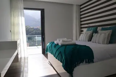 a bedroom with a bed and a large window at Casa Da Achada, By OP in São Vicente