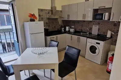 a kitchen with a white table and a white refrigerator at Franciscus 1a in Funchal