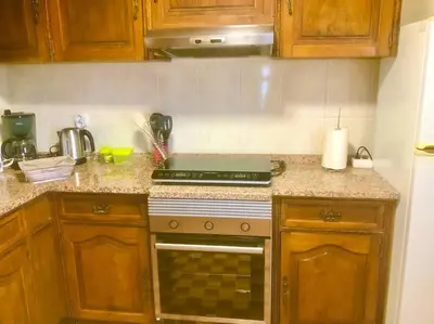 a kitchen with wooden cabinets and a stove top oven at Casa Vista Mar -2 bedrooms,fantastic Seaview in Estreito da Calheta