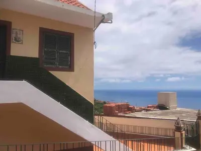 a building with a balcony with a view of the ocean at Casa Vista Mar -2 bedrooms,fantastic Seaview in Estreito da Calheta