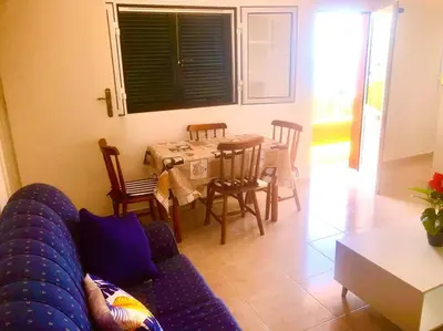 a living room with a couch and a table and chairs at Casa Vista Mar -2 bedrooms,fantastic Seaview in Estreito da Calheta