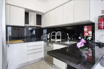 a kitchen with white cabinets and a black counter top at Arrifes View 2 Funchal by Rentallido in Funchal