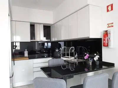 a kitchen with white cabinets and a black counter top at Arrifes View 2 Funchal by Rentallido in Funchal