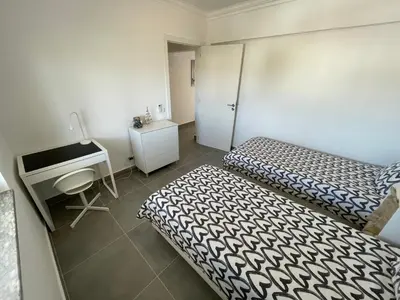 a room with two beds and a desk and a desk at Elm Apartament in Sagres