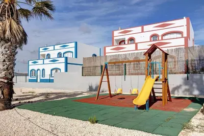 a playground with a slide in front of a building at Elm Apartament in Sagres