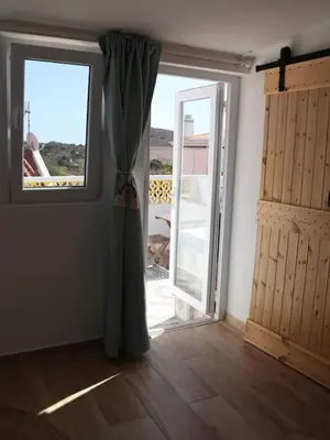 an empty room with a door and a window at Casa Vento Budens in Budens
