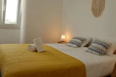a bedroom with a large bed with towels on it at Casa Vento Budens in Budens