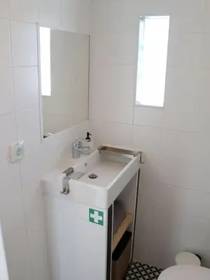 a white bathroom with a sink and a toilet at Casa Vento Budens in Budens