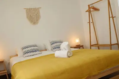 a bedroom with a yellow bed with towels on it at Casa Vento Budens in Budens