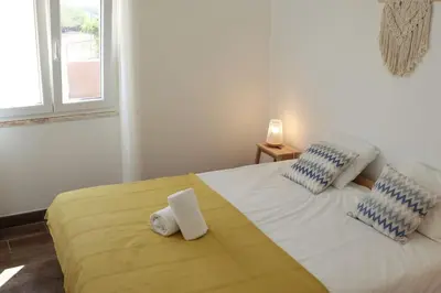 a bedroom with a bed with two towels on it at Casa Vento Budens in Budens