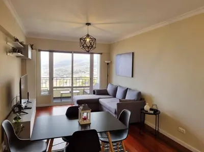 a living room with a couch and a table at Olimpia Gardens View by Rentallido in Funchal