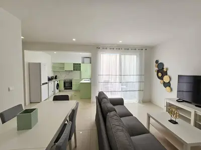 a living room with a couch and a table and a kitchen at Caminho da Achada Apartment Funchal by Rentallido in Funchal