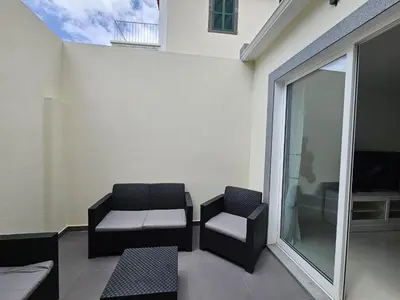 a patio with two chairs and a table and a window at Caminho da Achada Apartment Funchal by Rentallido in Funchal