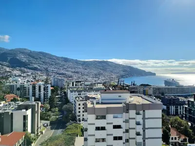 an aerial view of a city with buildings and the ocean at Infante Sunset Funchal by Rentallido in Funchal
