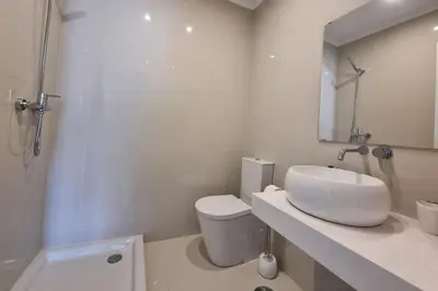 a white bathroom with a sink and a toilet at Infante Sunset Funchal by Rentallido in Funchal