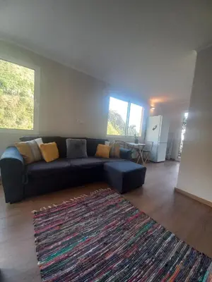 a living room with a blue couch and a rug at Levadinha - Nature guest house in Madalena do Mar