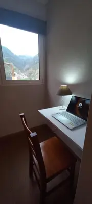 a laptop computer sitting on a desk with a window at Levadinha - Nature guest house in Madalena do Mar