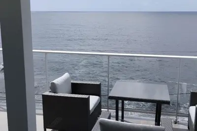 a balcony with a table and chairs on a ship at Apt 'A Gaioa' in 'The Cliff Coast Accomodation' in Paul do Mar