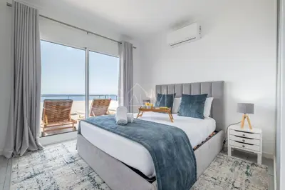 a bedroom with a bed and a large window at Esterinha's Ocean Apartment by GALMI in Jardim do Mar