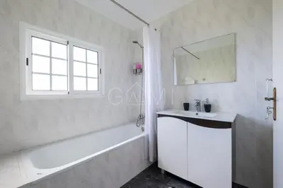 a white bathroom with a tub and a sink and a bath tubermott at Esterinha's Ocean Apartment by GALMI in Jardim do Mar