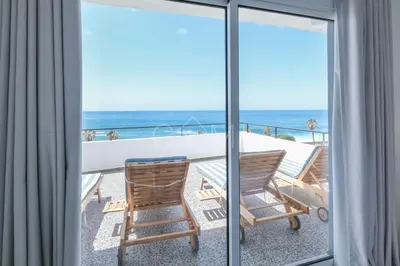a balcony with a table and chairs and the ocean at Esterinha's Ocean Apartment by GALMI in Jardim do Mar