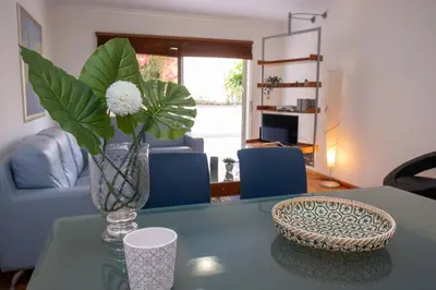 a vase with flowers on a table in a living room at Elsa's Place II in Funchal
