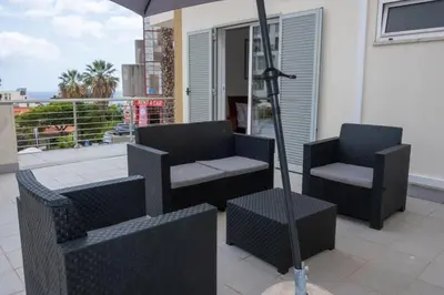 two chairs and an umbrella on a balcony at Elsa's Place II in Funchal