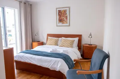 a bedroom with a bed and a blue chair at Elsa's Place II in Funchal
