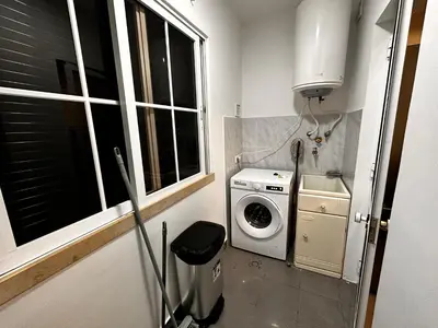 a laundry room with a washing machine and a window at SÃO GONÇALO APARTAMENTO in Funchal